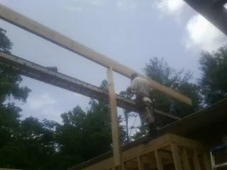 Carpenter setting a ridge beam over a new addition frame — Ice Dam Removal by Roofing Brothers in Ocean Beach