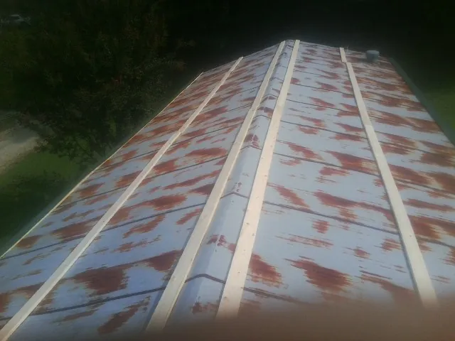 Rusted metal roof panels with new wood purlins before replacement — Storm Damage Roof Repair in Ocean Beach by Roofing Brothers